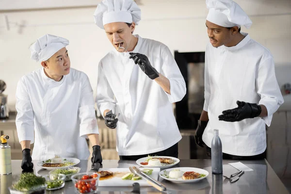 Cozinheiros com diferentes nacionalidades degustação de refeições cozidas para menu de restaurante — Fotografia de Stock