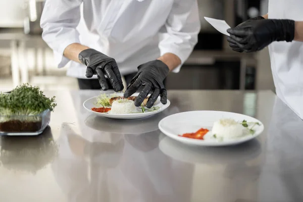 Cooks finishing main courses in the restaurant kitchen — Stock Photo, Image