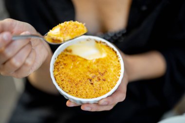 Açık hava restoranında creme brulee ile tatlı yemek.
