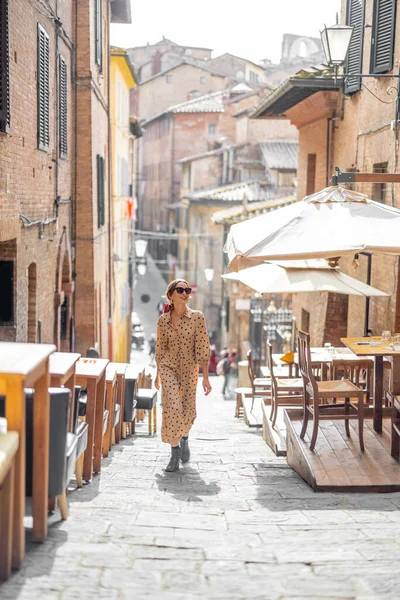 Donna Sylish cammina su una strada stretta e accogliente nel centro storico di Siena — Foto Stock