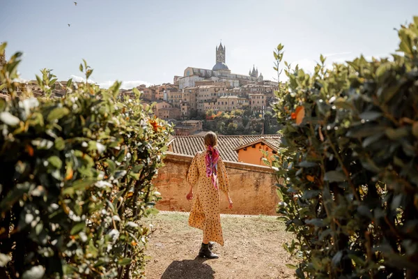 Woman walks on background of cityscape of Siena old town in Italy Royalty Free Stock Photos