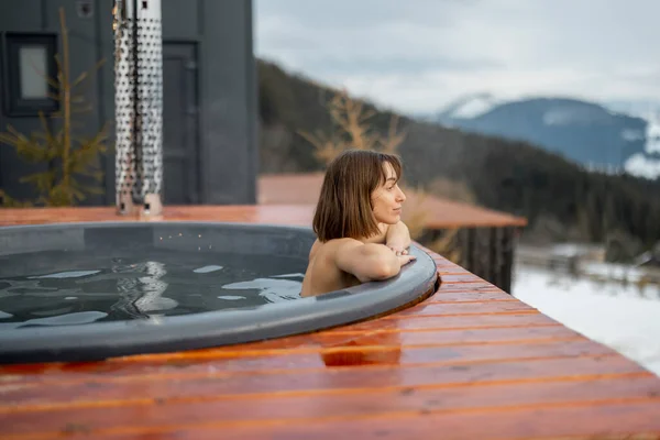 Mulher tomando banho na banheira de hidromassagem nas montanhas — Fotografia de Stock