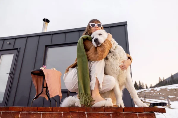 Mulher com seu cão descansando no terraço da minúscula casa na natureza — Fotografia de Stock