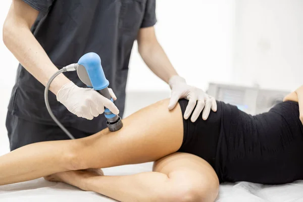 El médico aplica terapia de ondas de choque en la rodilla de las mujeres — Foto de Stock