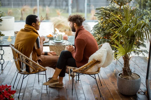 Dwóch wielorasowych mężczyzn rozmawiających ze sobą przy stole na podwórku — Zdjęcie stockowe