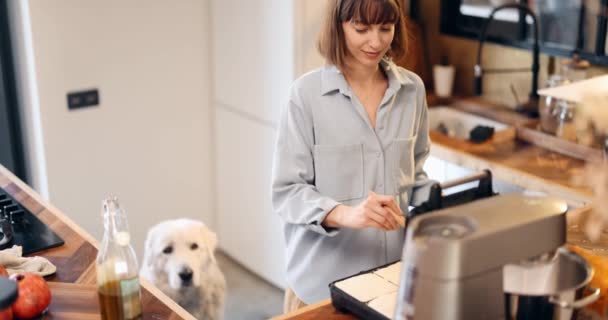 女人在家里做饭的时候喂她的大狗 — 图库视频影像