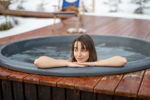 Mujer bañándose en bañera de hidromasaje en las montañas — Foto de Stock