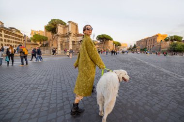Roma 'nın ünlü merkez caddesinde bir köpekle yürüyen bir kadın.