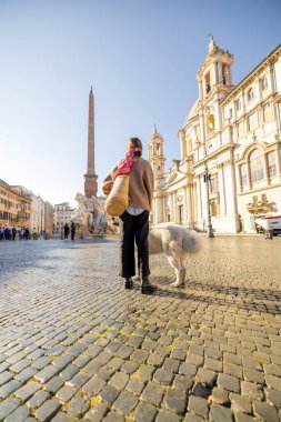 Roma 'daki Navona meydanında İtalyan çoban köpeğiyle yürüyen bir kadın.