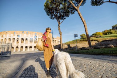 Roma 'da Coliseum yakınlarında bir köpekle yürüyen bir kadın.