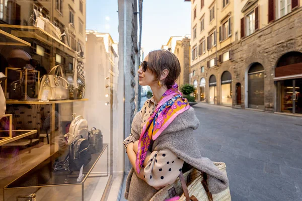 Γυναίκα κοιτάζει σε μια βιτρίνα με τσάντες στο δρόμο στην παλιά πόλη — Φωτογραφία Αρχείου