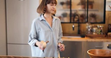 Kadın ev mutfağında yemek yapmaya hazırlanıyor.