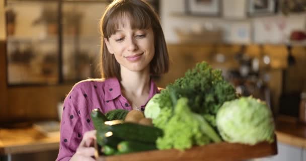 Retrato de una mujer sosteniendo verduras y verduras frescas en casa — Vídeo de stock