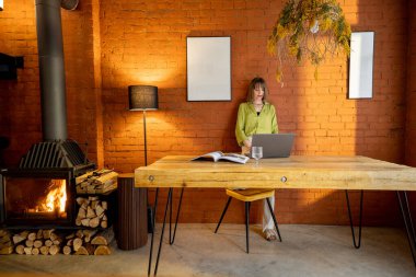 Evdeki rahat oturma odasında duran zarif bir kadının portresi..