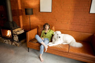 Beyaz sevimli köpeğiyle sarılmış bir kadın.