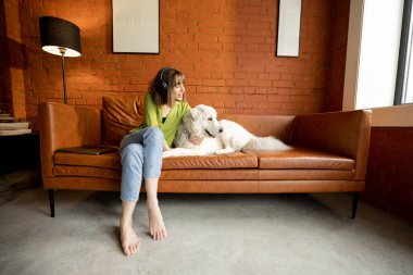 Beyaz sevimli köpeğiyle sarılmış bir kadın.