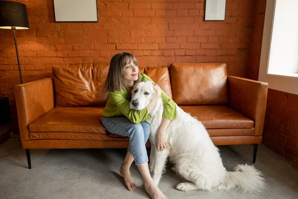 집에서 흰 사랑 스러운 개와 포옹하는 여자 — 스톡 사진