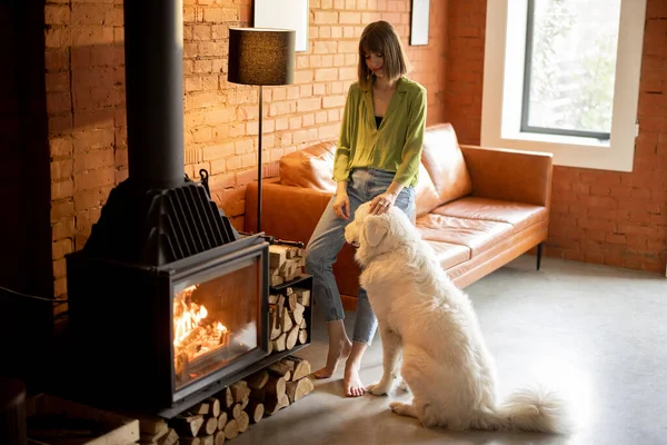女人喂着她那只可爱的白狗，在家里呆着 — 图库照片