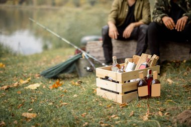 Odunlu tahta kutu ve piknikte alkollü içeceklerle dolu şişeler.