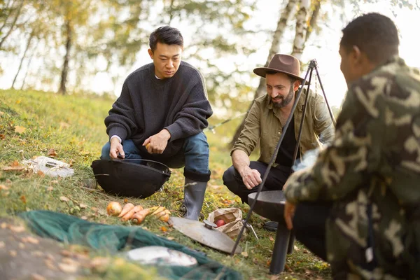 Çok ırklı arkadaşlar balık tutarken piknik yapıyorlar. — Stok fotoğraf