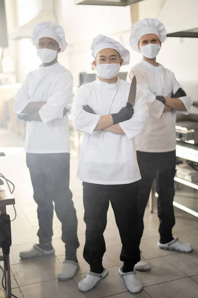 Portret van chef-kok koks met verschillende etniciteiten die samen staan in restaurant keuken — Stockfoto