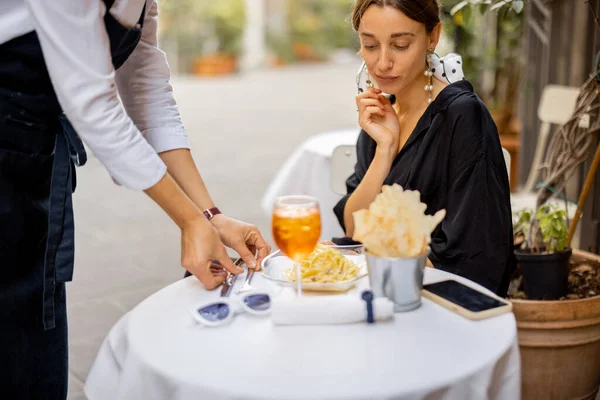 Servitör serveringsbord för en ung kvinna kund utomhus — Stockfoto