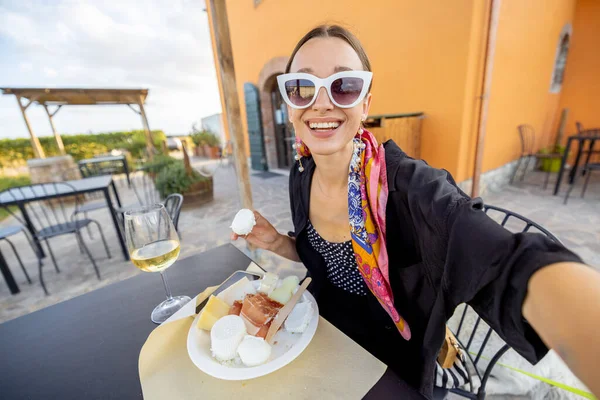 İtalya 'da yerel bir çiftlik dükkanında peynir ve şarap tatmakta olan bir kadın. — Stok fotoğraf