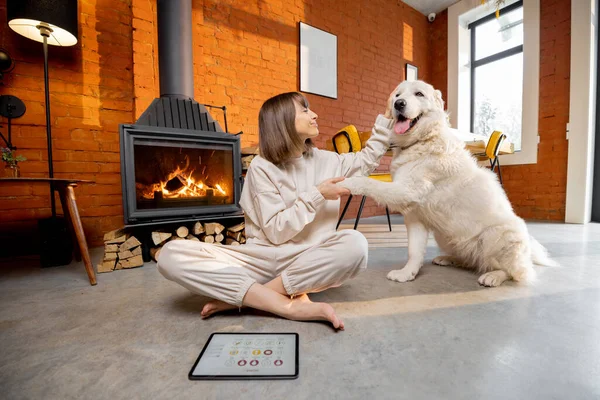 Femme assise détendue avec son chien sur le sol près de la cheminée à la maison — Photo