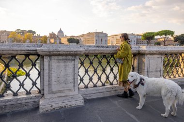 Köpekli kadın Roma 'nın sabahları manzarasını seyrediyor.