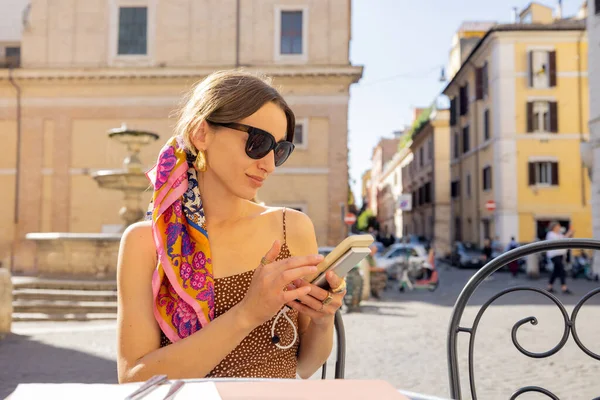 Woman sitting with phone at outdoor cafe or restaurant in Rome — Stock Photo, Image