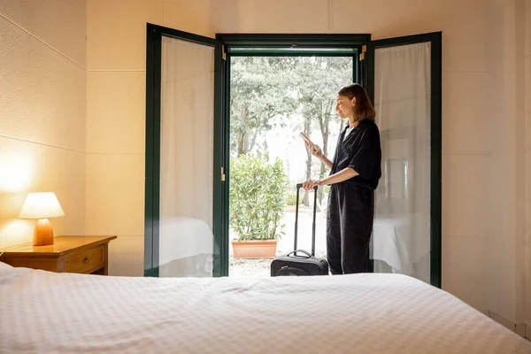 Vrouw met bagage op oude stijl hotelkamer — Stockfoto