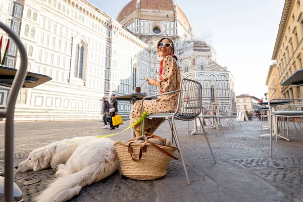 Γυναίκα κάθεται με το σκυλί της στη βεράντα του καφέ κοντά στο διάσημο καθεδρικό ναό Duomo στη Φλωρεντία — Φωτογραφία Αρχείου