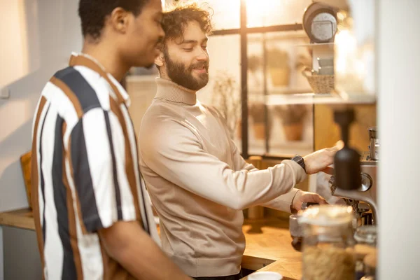 Dois homens conversando e bebendo café na cozinha em casa — Fotografia de Stock