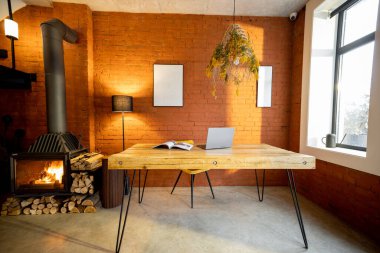 Oturma odasının içinde ahşap bir yemek masası ve şöminesi var.