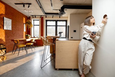 Kadın ev sıcaklığını elektronik termostatla kontrol ediyor