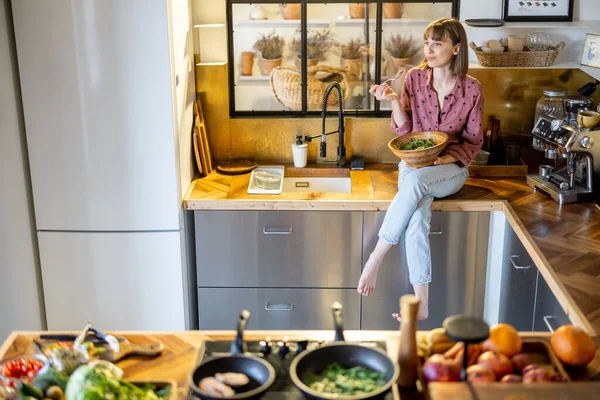 在家里现代厨房里吃沙拉的女人 — 图库照片