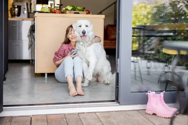 Vrouw zit samen met haar schattige enorme hond thuis — Stockfoto