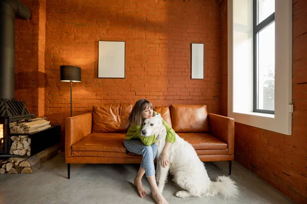Wanita berpelukan dengan anjing putihnya di rumah. — Stok Foto