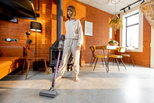 Wanita membersihkan lantai dengan vacuum cleaner genggam — Stok Foto