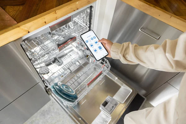 Mengendalikan mesin cuci piring dengan aplikasi telepon pintar — Stok Foto