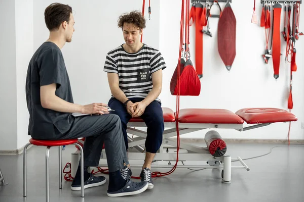 Man having consultation with physiotherapist at rehabilitation office — Stock Photo, Image