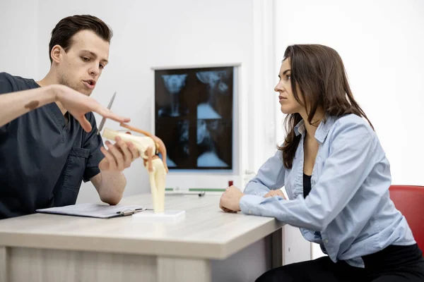 Jonge vrouw in overleg met een fysiotherapeut op kantoor — Stockfoto