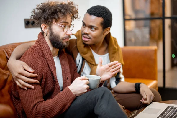 Masculino gay casal falando no um sofá no casa — Fotografia de Stock