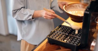 Evde waffle yapan bir kadın.