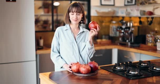 Kvinna med granatäpplen i köket — Stockvideo