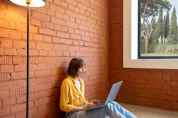 Kvinna arbetar ensam på bärbar dator hemma — Stockfoto