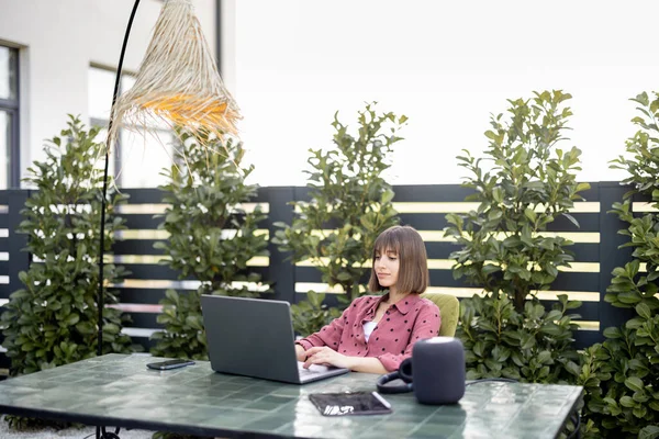 Woman works on laptop online in the garden outdoors — Stock Photo, Image