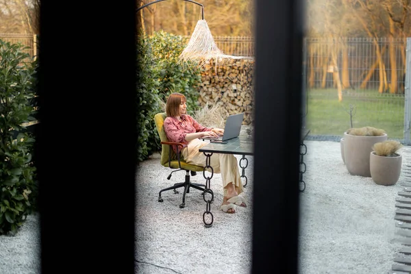 Женщина работает в открытом офисе в красивом саду — стоковое фото
