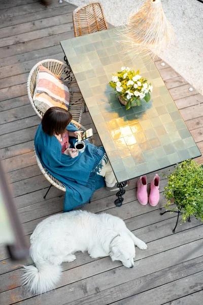 Mujer en cuadros relajante en la terraza del hogar —  Fotos de Stock