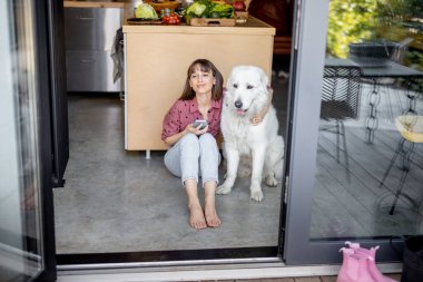Kadın, tapılası büyük köpeğiyle birlikte evde oturuyor.